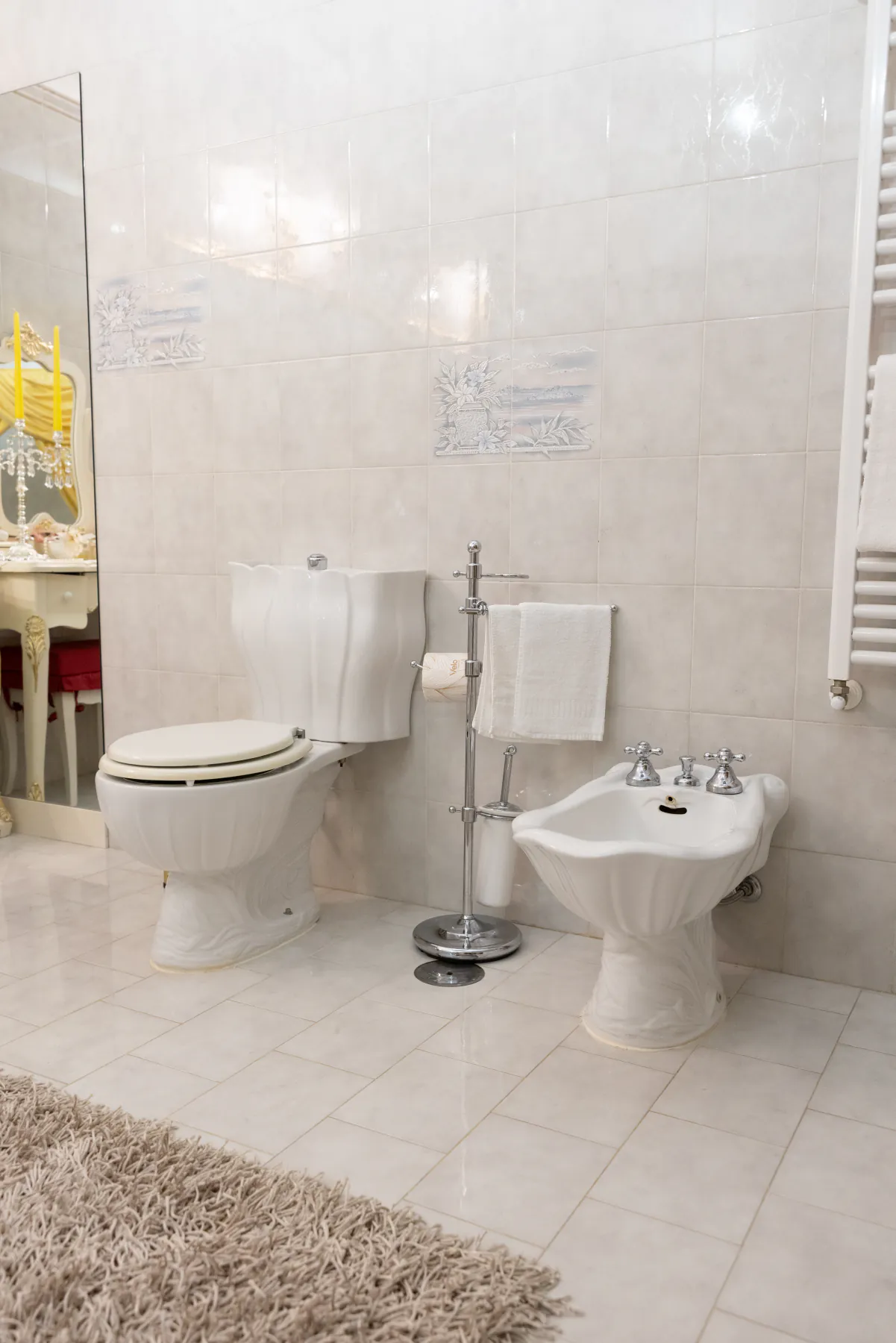Un bagno della villa in marmo chiaro, con i sanitari e il tappeto
