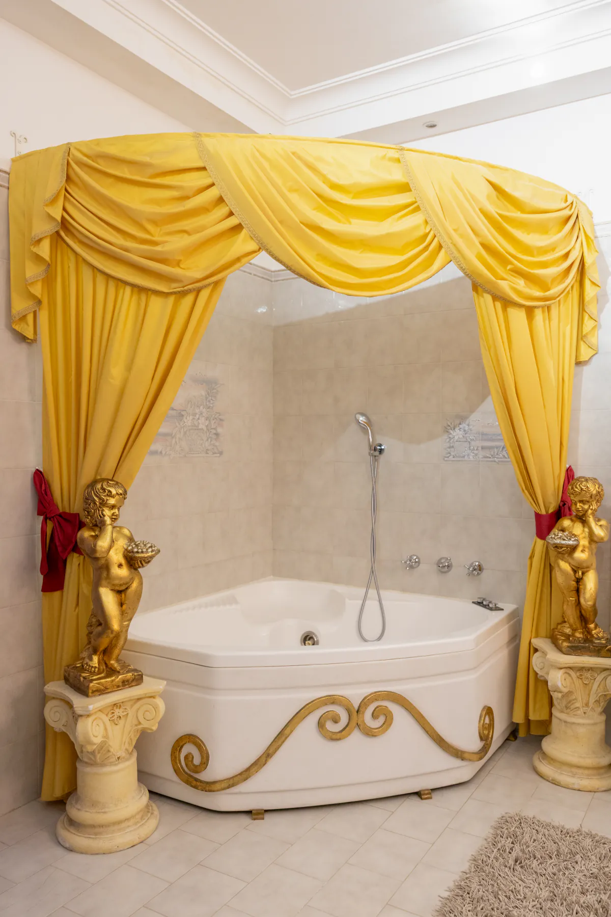 La vasca idromassaggio ad angolo di un bagno della villa, tra i drappeggi gialli