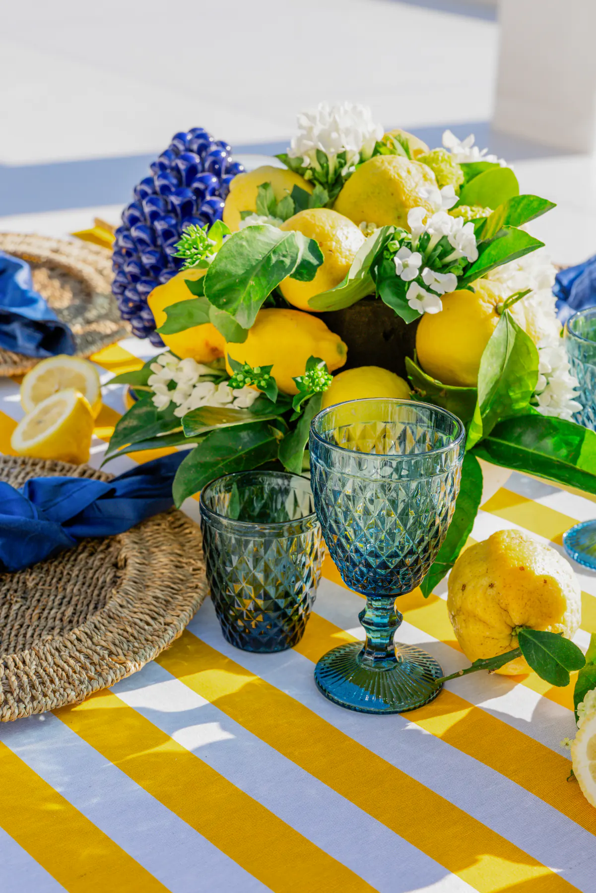Il centrotavola di limoni, fiori bianchi e bicchieri di vetro verde