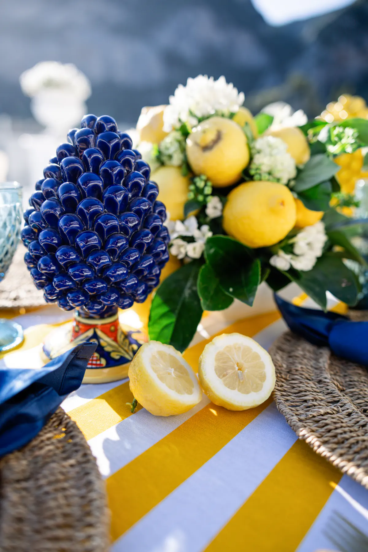 Il dettaglio della pigna di ceramica blu tra i limoni del centrotavola
