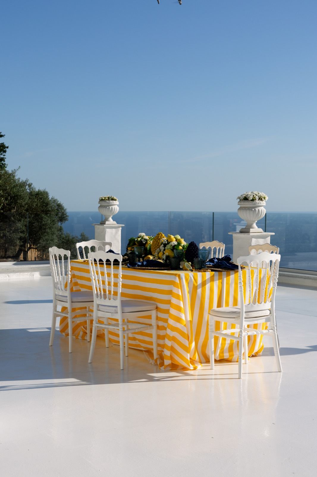 La tavola degli sposi con i limoni e le righe gialle, sulla terrazza bianca sul mare