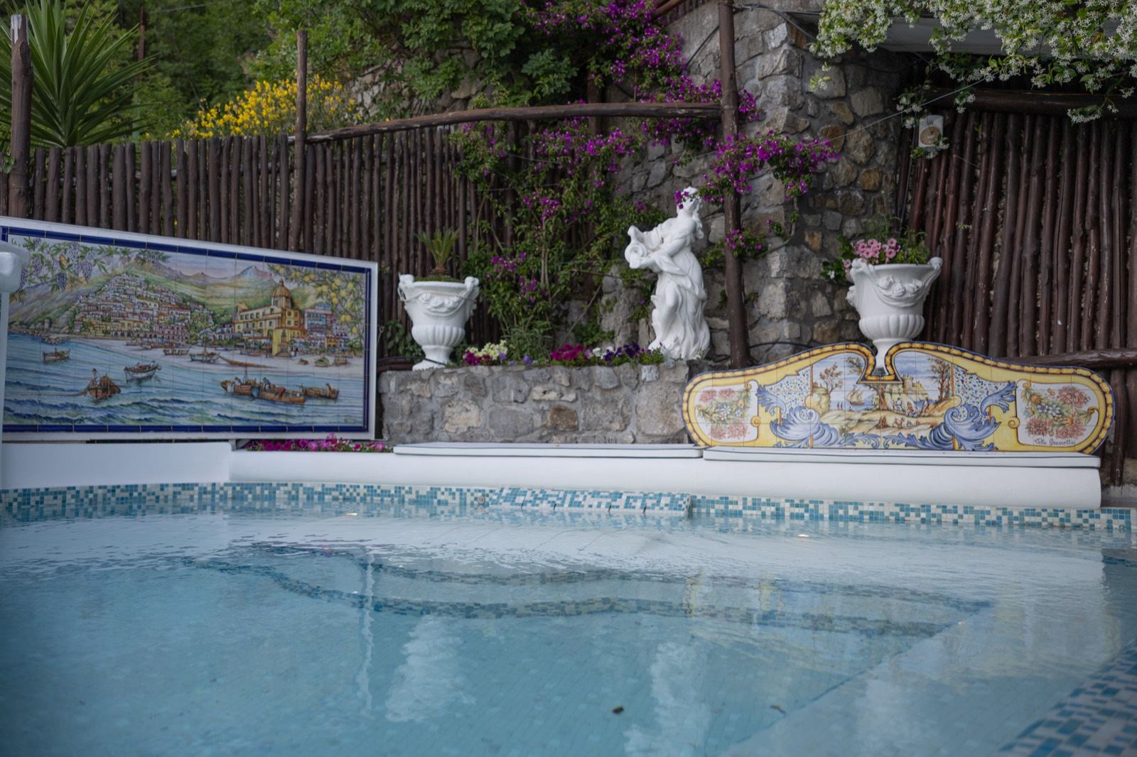 La piscina di Villa Graziella tra le maioliche e le statue del giardino