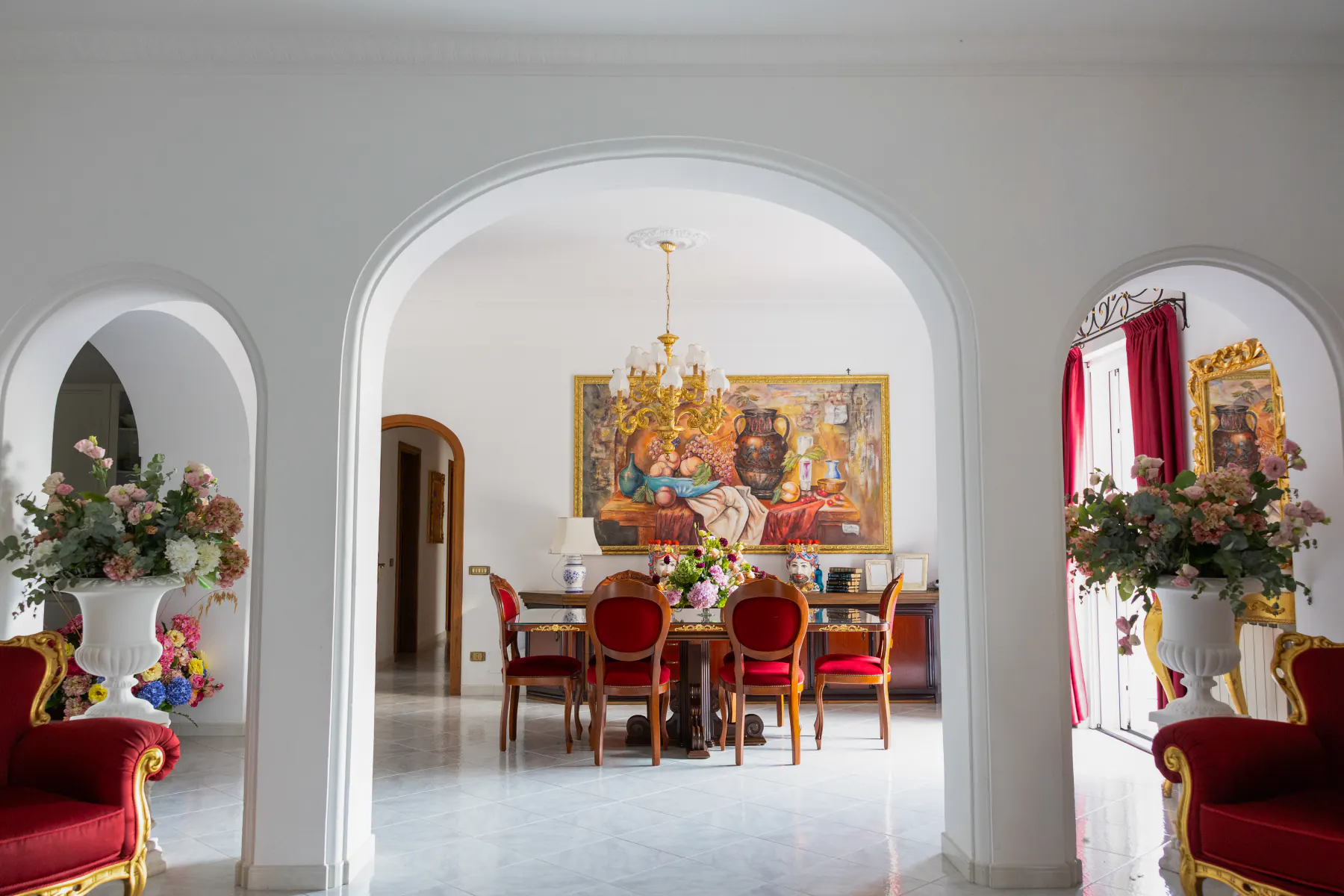 Le sale della villa viste attraverso gli archi bianchi