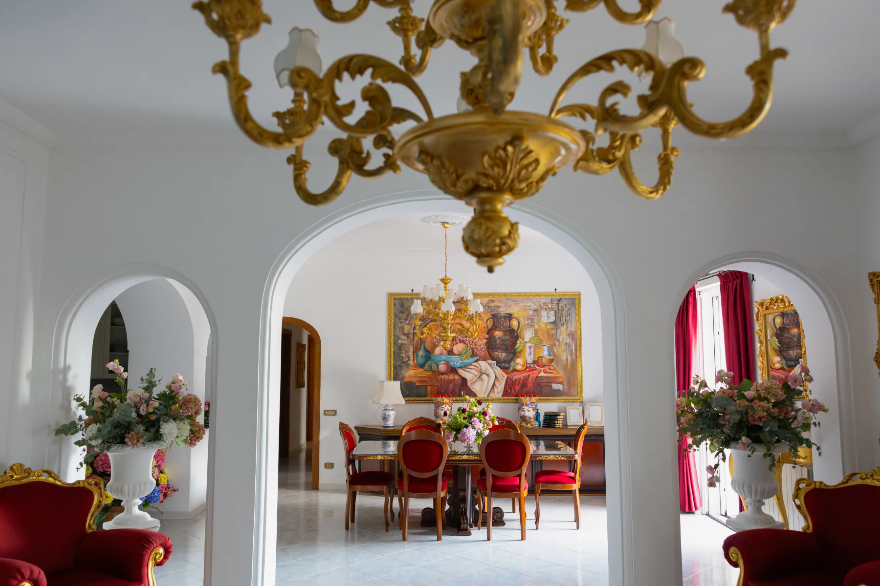 Il salone di Villa Graziella con gli archi bianchi e il lampadario dorato