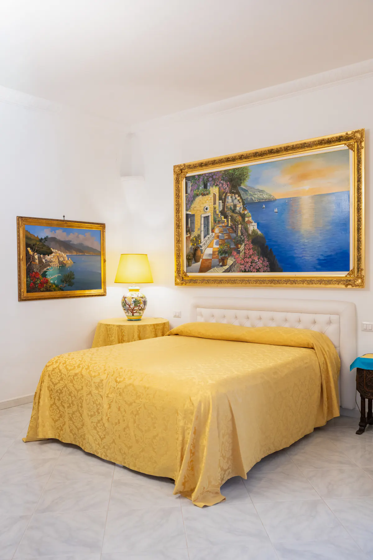 Una delle quattro suite della villa, con i dipinti della Costiera Amalfitana