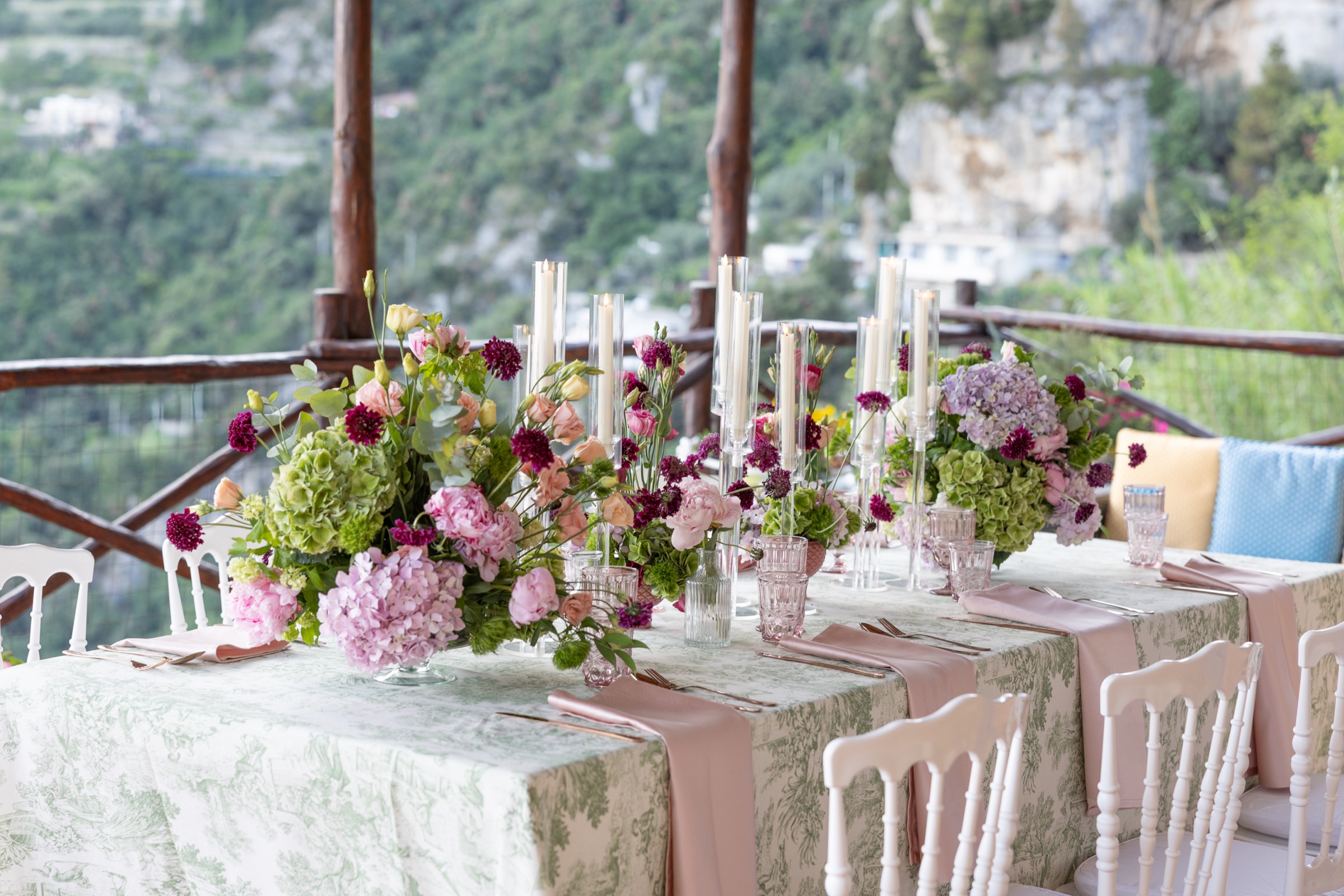 The reception table dressed under the pergola, with flowers and candles